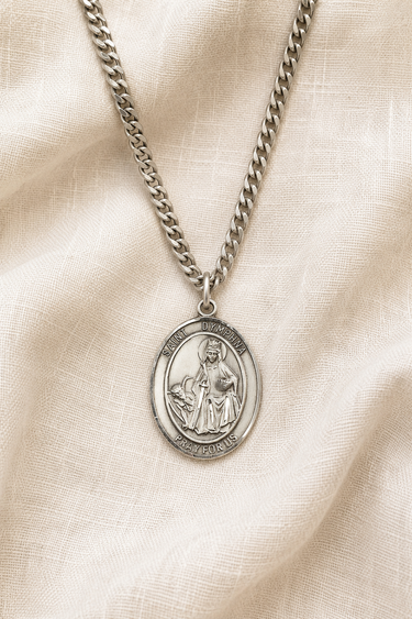 Sterling Silver St Dymphna medal necklace with a pendant on a beige fabric background