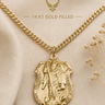 A gold Air Force pendant necklace displayed on a beige fabric background with decorative dried flowers. The image includes text reading 'AIR FORCE' and '14 KT GOLD FILLED' with a winged emblem above.