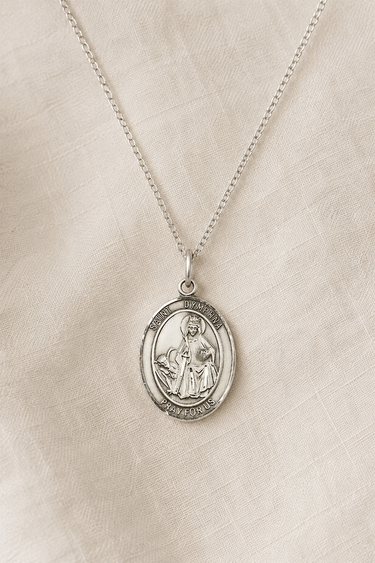Sterling Silver St Dymphna pendant necklace for women on a beige fabric background