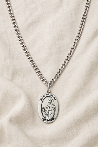 Sterling Silver St Dymphna necklace with a oval pendant on a beige fabric background and 24" chain