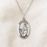 Sterling Silver pendant necklace with 'Saint Dymphna' on a beige fabric background