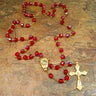 Red glass Catholic rosary with Holy Sand center medallion, golden tone chain and crucifix, 19 inch length, made in Italy