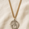 St Dymphna 14KT Gold Filled round medal necklace on a beige fabric background