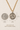 Saint Dymphina Gold Filled medal necklace with gold plated  chain on a textured beige background