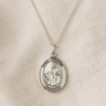 Sterling Silver St Dymphna pendant necklace for women on a beige fabric background