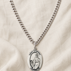 Sterling Silver St Dymphna necklace with a oval pendant on a beige fabric background and 24" chain