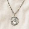 Sterling Silver St Dymphna medal necklace with a pendant on a beige fabric background