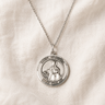 Sterling Silver St Dymphna round medal necklace for women with a pendant on a beige fabric background